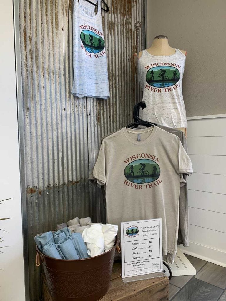 display of Wisconsin River Trail Organization t-shirts and tank tops for sale at Willow and Ivy
